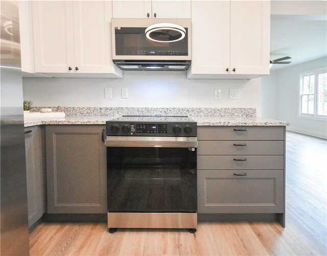 kitchen featuring hanging light fixtures, appliances with stainless steel finishes, and white cabinetry