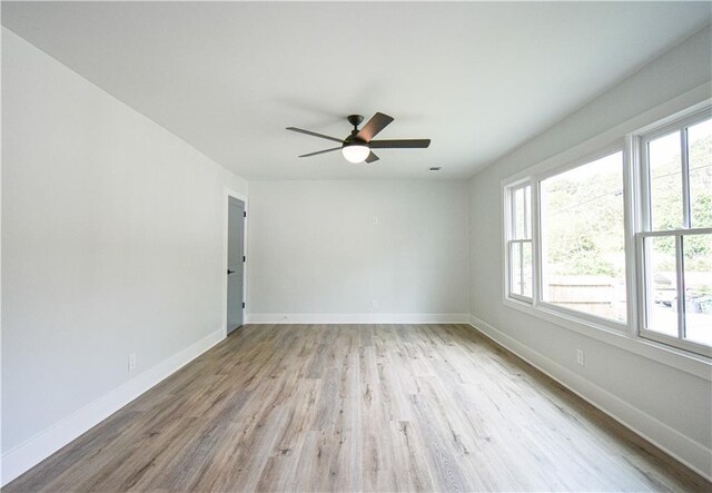 entrance foyer with a wall mounted air conditioner, baseboards, visible vents, and light wood finished floors