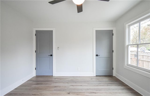 unfurnished bedroom featuring baseboards, ceiling fan, and light wood-style floors