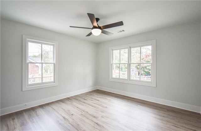 spare room featuring ceiling fan, a healthy amount of sunlight, and light hardwood / wood-style floors