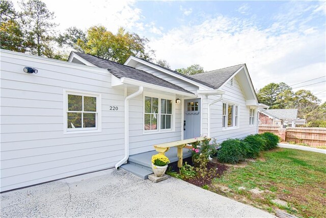 single story home featuring driveway, fence, and a front lawn