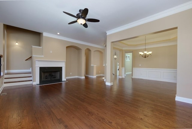 unfurnished living room with crown molding, ceiling fan with notable chandelier, dark hardwood / wood-style flooring, and a tray ceiling