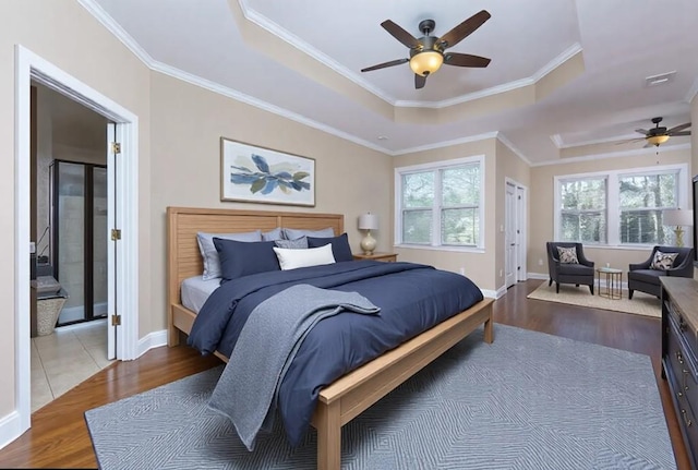 bedroom featuring a raised ceiling, ornamental molding, and hardwood / wood-style flooring