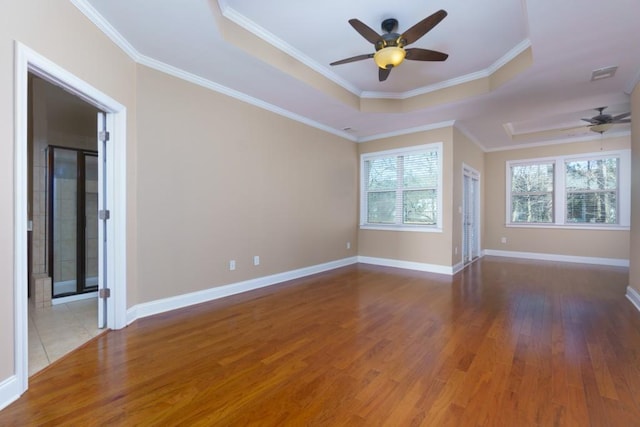 spare room featuring crown molding, a tray ceiling, ceiling fan, and hardwood / wood-style flooring