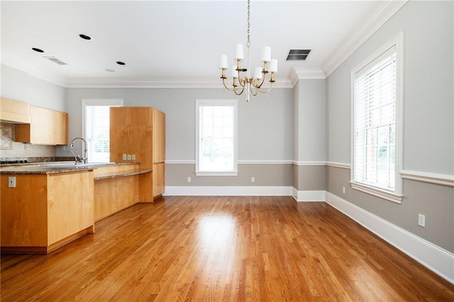 3657 Peachtree Rd NE Unit 4A, Atlanta, GA 30319 - kitchen featuring a chandelier, light wood finished floors, ornamental molding, decorative light fixtures, and decorative backsplash