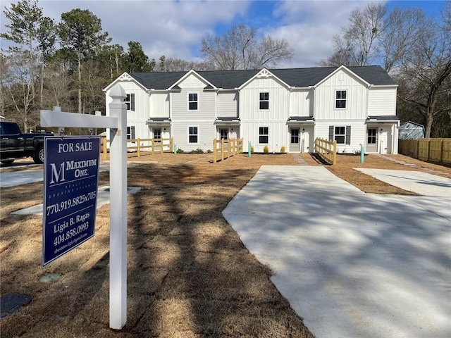 view of front facade with board and batten siding and fence