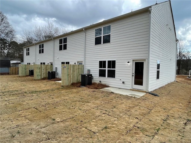 back of property with a yard, a patio area, and central air condition unit