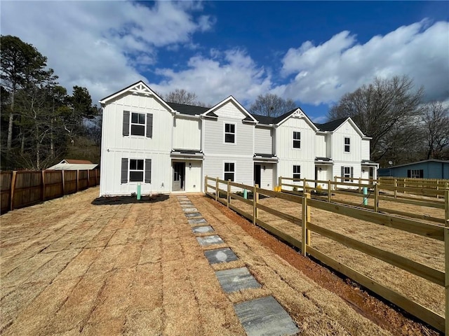 view of front of home featuring board and batten siding and fence private yard