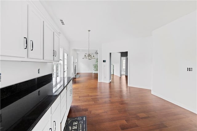 kitchen with white cabinets, pendant lighting, dark hardwood / wood-style floors, and a notable chandelier