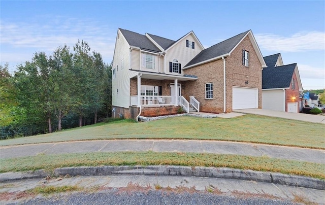 view of front of home featuring a front yard, a porch, and a garage