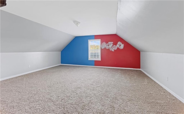 additional living space featuring carpet flooring and vaulted ceiling