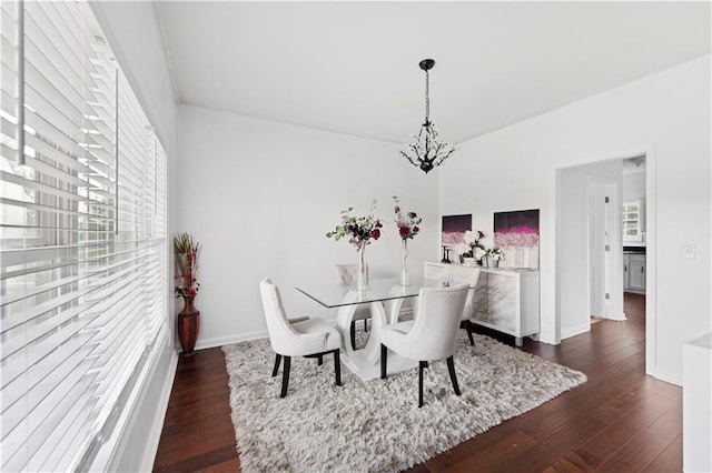 dining space featuring dark hardwood / wood-style flooring and a chandelier