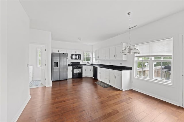 kitchen featuring black appliances, decorative light fixtures, white cabinets, and dark wood-type flooring