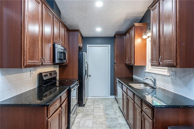 kitchen featuring stainless steel appliances, dark stone counters, a textured ceiling, sink, and tasteful backsplash