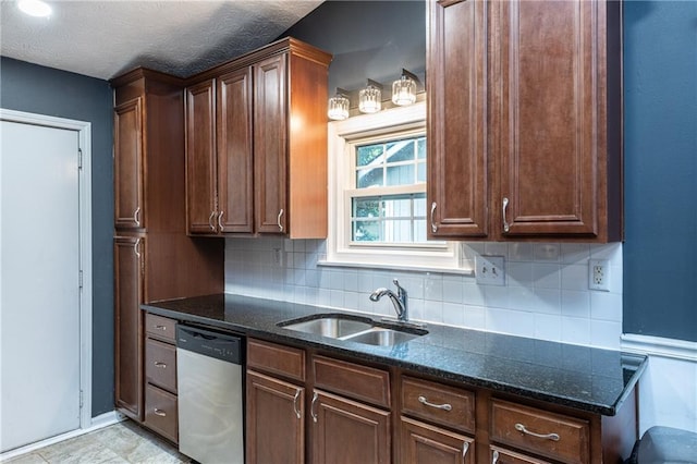 kitchen with stainless steel dishwasher, dark stone countertops, tasteful backsplash, and sink