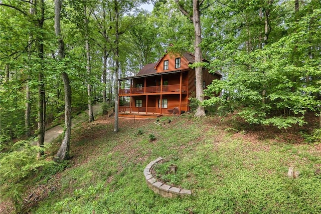 back of property with a view of trees and a wooden deck