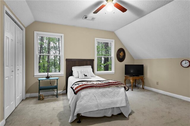 carpeted bedroom with baseboards, multiple windows, lofted ceiling, and visible vents