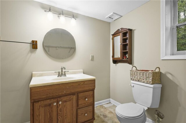bathroom featuring vanity, baseboards, and toilet