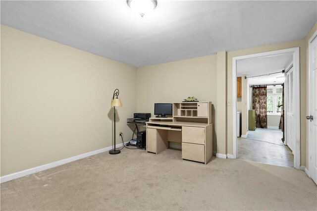 office area with baseboards and light carpet