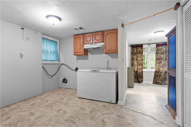 clothes washing area featuring visible vents and cabinet space