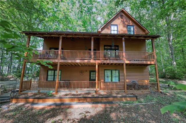 rear view of house featuring faux log siding