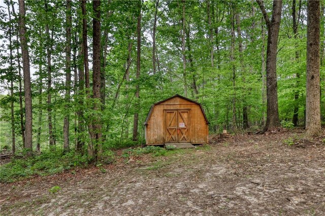 view of shed featuring a view of trees