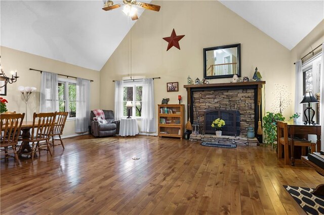 living area featuring high vaulted ceiling, ceiling fan, a fireplace, and hardwood / wood-style flooring
