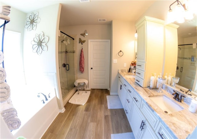 bathroom featuring vanity, wood-type flooring, and separate shower and tub