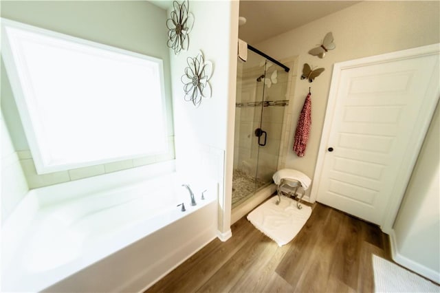 bathroom featuring wood-type flooring and plus walk in shower