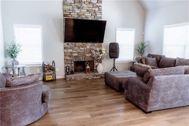 living room with light hardwood / wood-style flooring, a fireplace, and vaulted ceiling