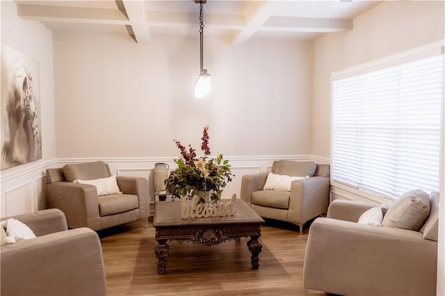 living area with coffered ceiling, light hardwood / wood-style floors, and beam ceiling