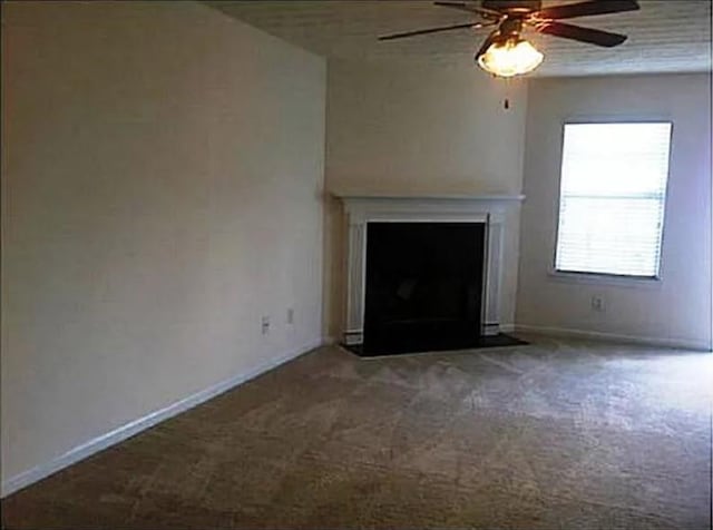 unfurnished living room featuring carpet floors and ceiling fan