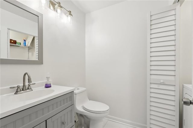 bathroom with vanity, toilet, washer / dryer, and tile patterned flooring