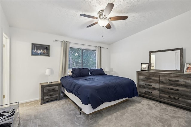 carpeted bedroom with vaulted ceiling, ceiling fan, and a textured ceiling