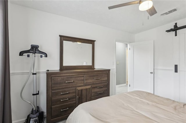 bedroom featuring a barn door and ceiling fan