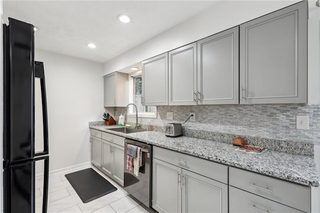 kitchen featuring sink, gray cabinets, stainless steel dishwasher, and black fridge