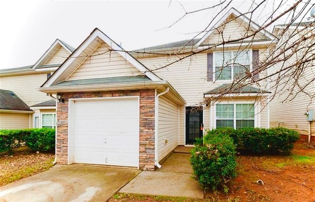 225 Colser Dr, Covington, GA 30016 - view of front facade with a garage, concrete driveway, and stone siding