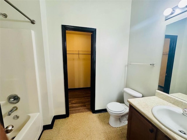 225 Colser Dr, Covington, GA 30016 - bathroom featuring tile patterned floors, toilet, vanity, a spacious closet, and baseboards