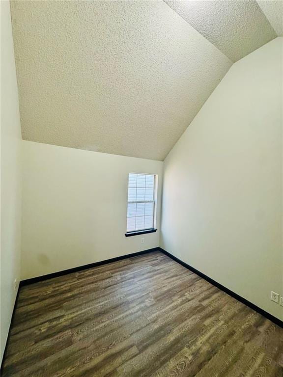225 Colser Dr, Covington, GA 30016 - additional living space with vaulted ceiling, a textured ceiling, wood finished floors, and baseboards