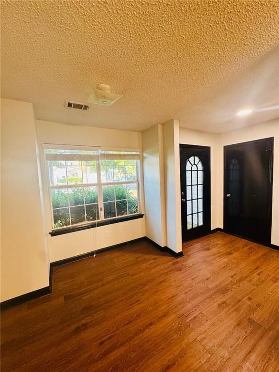 225 Colser Dr, Covington, GA 30016 - entrance foyer with wood finished floors, a textured ceiling, baseboards, and plenty of natural light