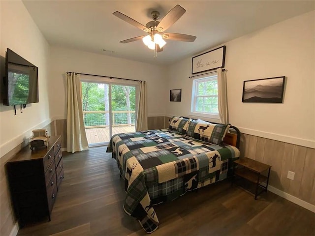 bedroom featuring multiple windows, ceiling fan, dark hardwood / wood-style floors, and access to exterior