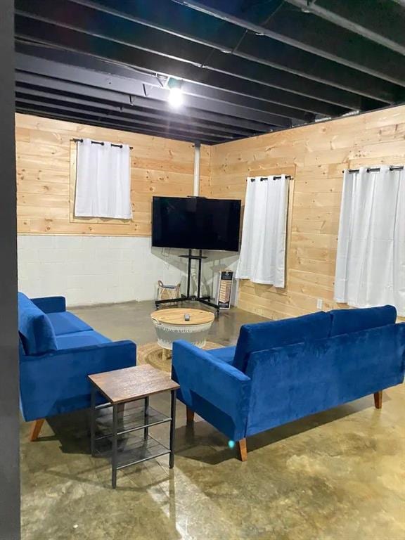 living room featuring concrete flooring and wooden walls