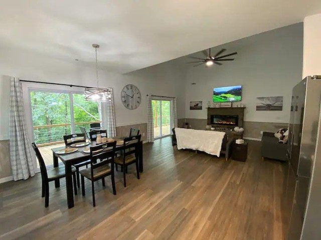 dining room with dark hardwood / wood-style flooring, vaulted ceiling, and ceiling fan