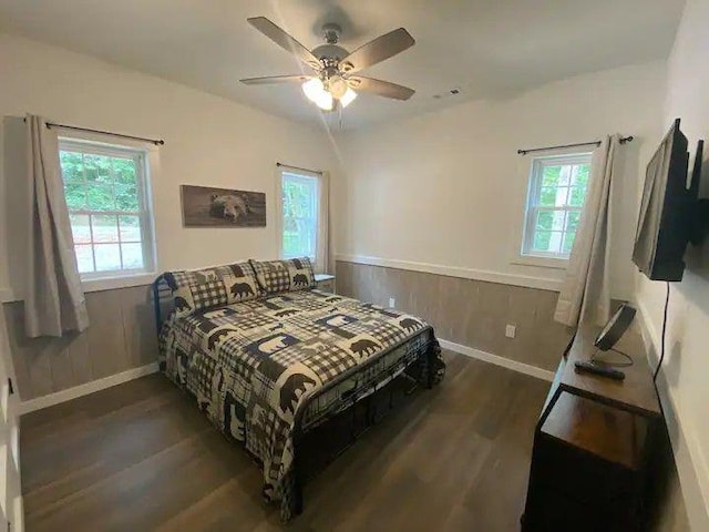 bedroom featuring dark hardwood / wood-style flooring, multiple windows, and ceiling fan