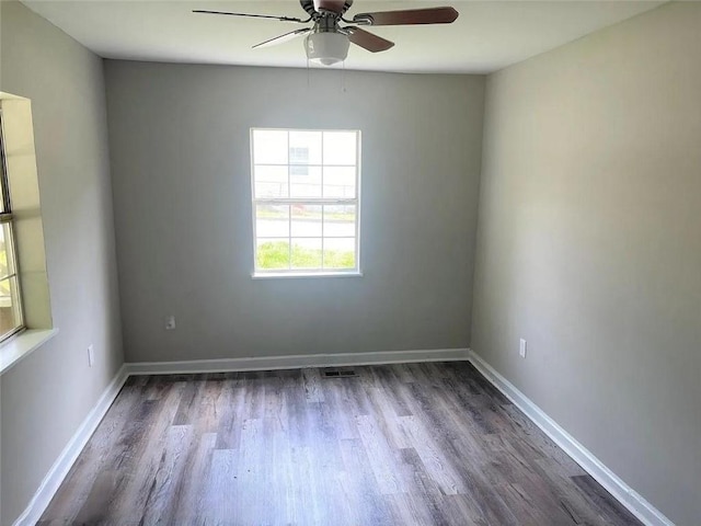 unfurnished room featuring ceiling fan and dark wood-type flooring