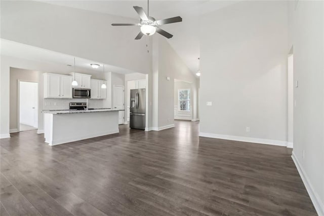 unfurnished living room featuring ceiling fan, high vaulted ceiling, dark wood-style flooring, and baseboards