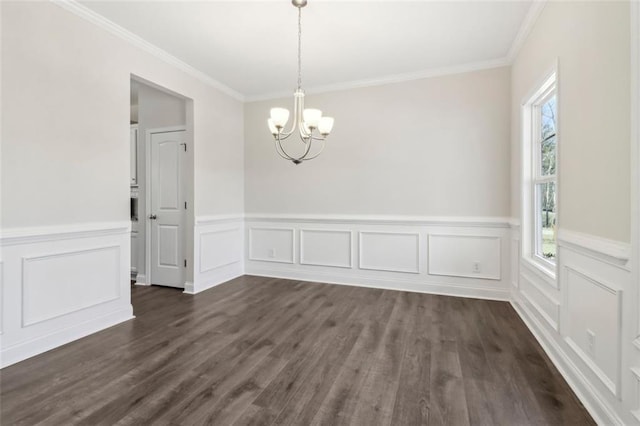 spare room with an inviting chandelier, crown molding, and dark wood-type flooring