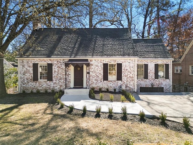 cape cod-style house with a front yard and brick siding