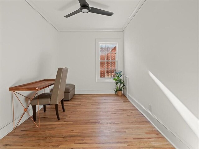 office area with a ceiling fan, light wood-type flooring, ornamental molding, and baseboards