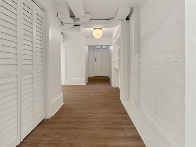 hall with baseboards and wood finished floors